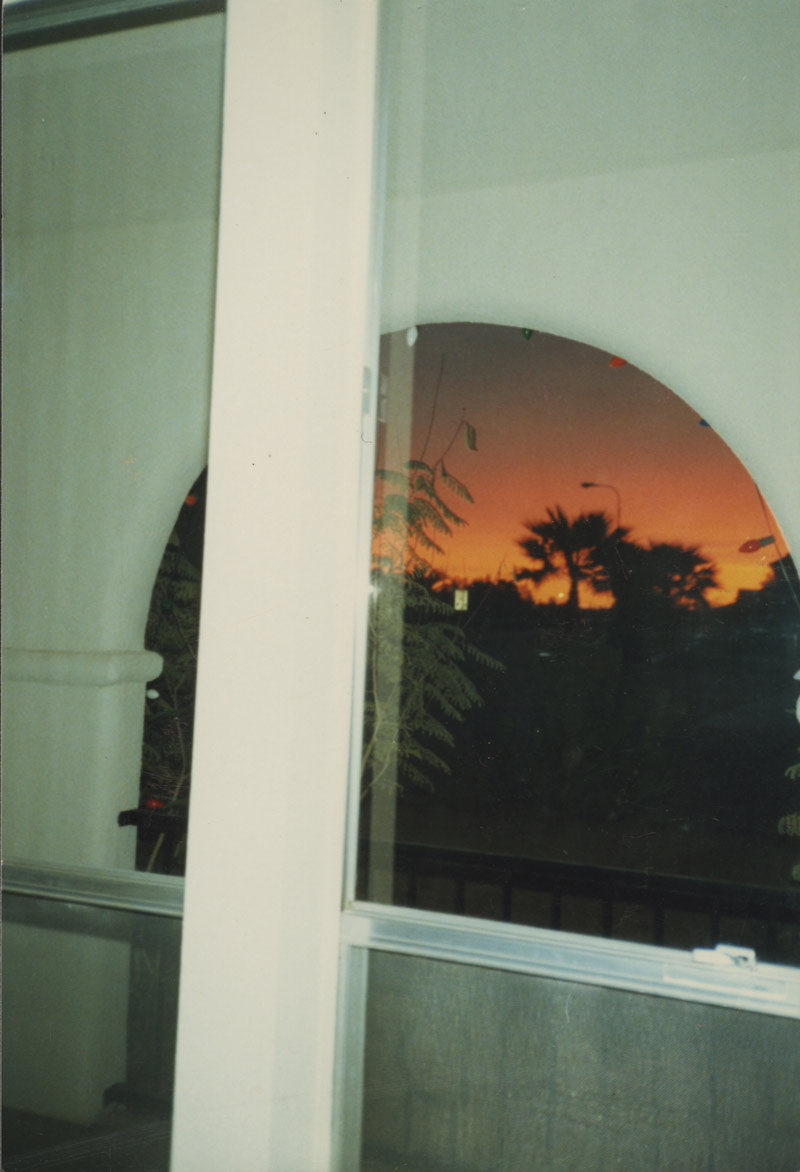 Isaac Pool, Debbee Pool, Grandparents house, Mesa AZ circa 1987. A sunset taken from inside a home framed by an archway on a patio and then again by a glass window and window frame